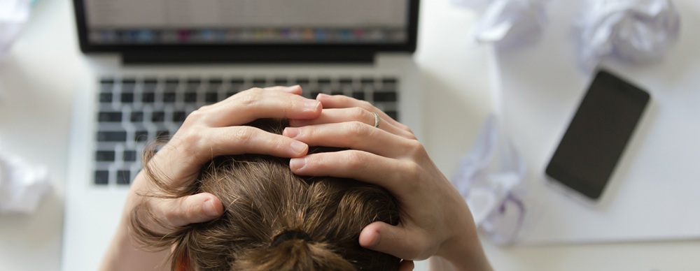 image-to-ilustrate-article-on-hyperscaler-dominance-shows-woman-with-head-in-hands-at-laptop