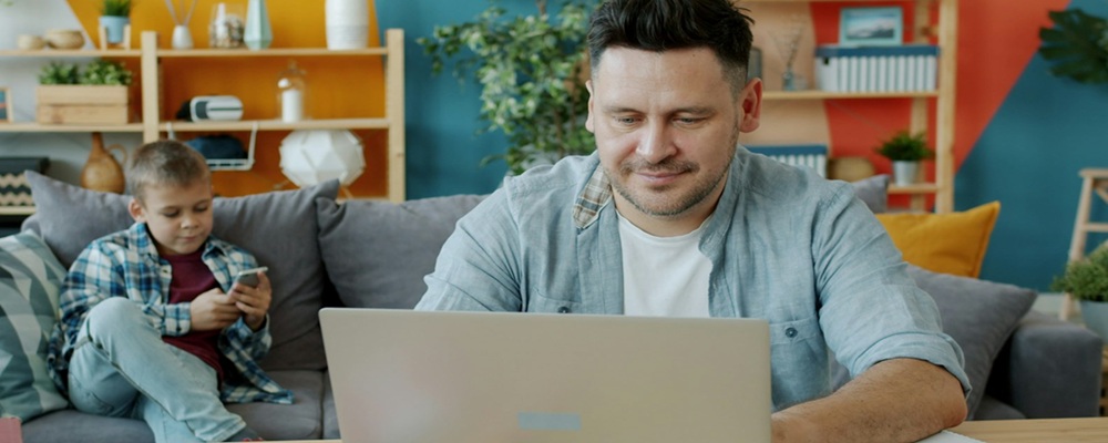 image-of-father-on-laptop-and-son-on-mobile-phone-to-illustrate-article-on-Predators-to-Platforms_the-Shift-in-Digital-Risk